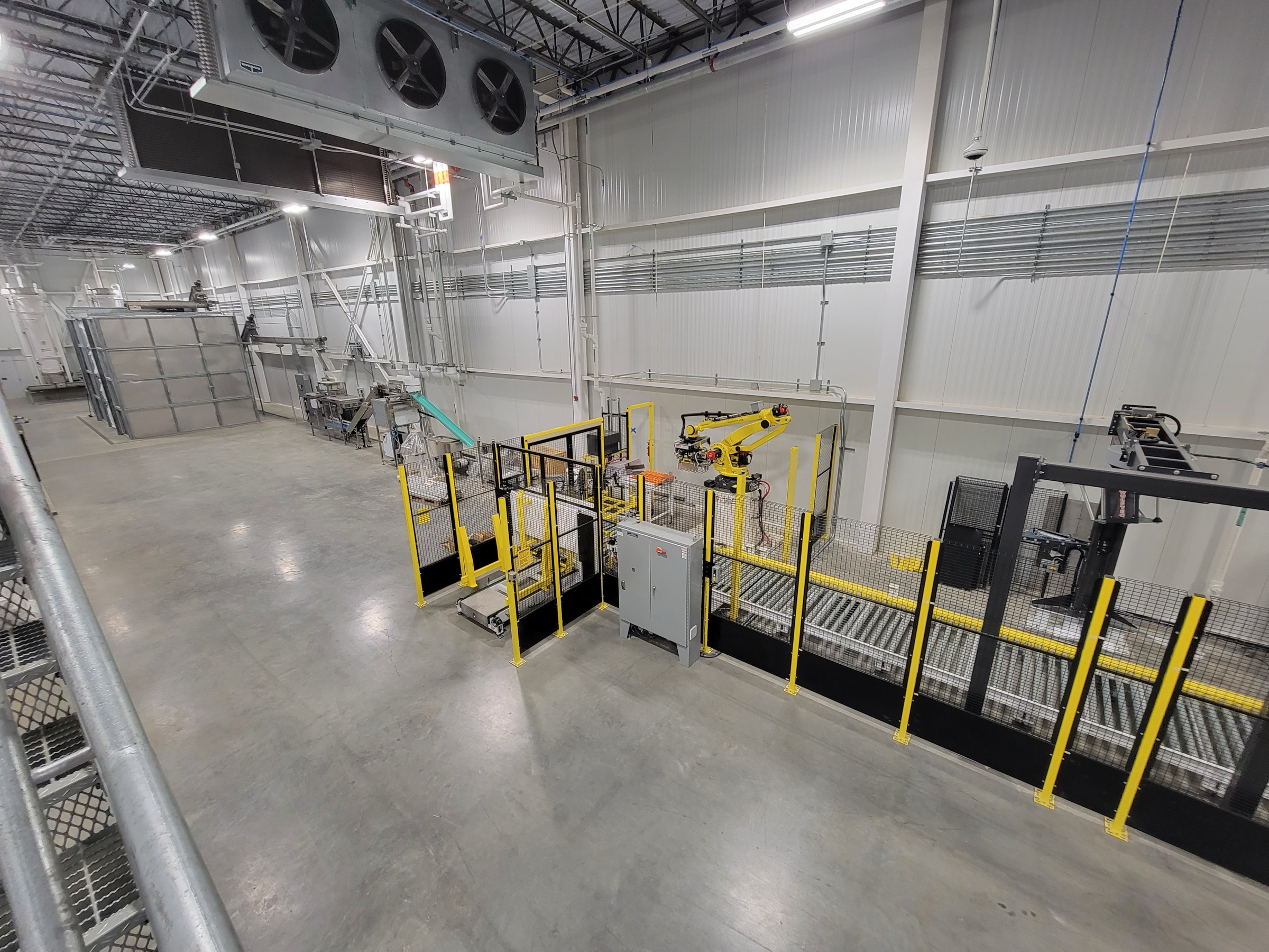Guarded robot cell installed in an industrial production facility