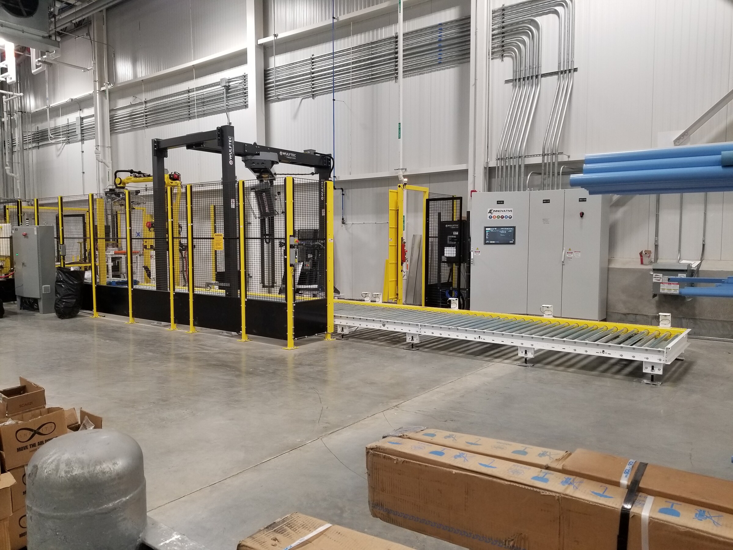 Robotic cell enclosed by perimeter wire mesh guarding on a production floor