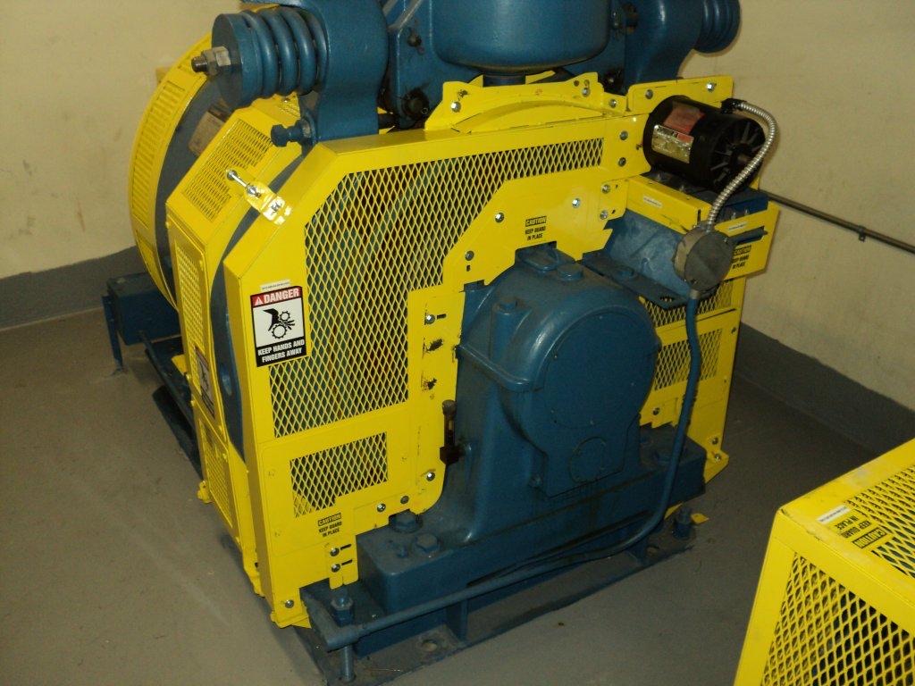 Yellow component guard panels enclosing a machine drive assembly