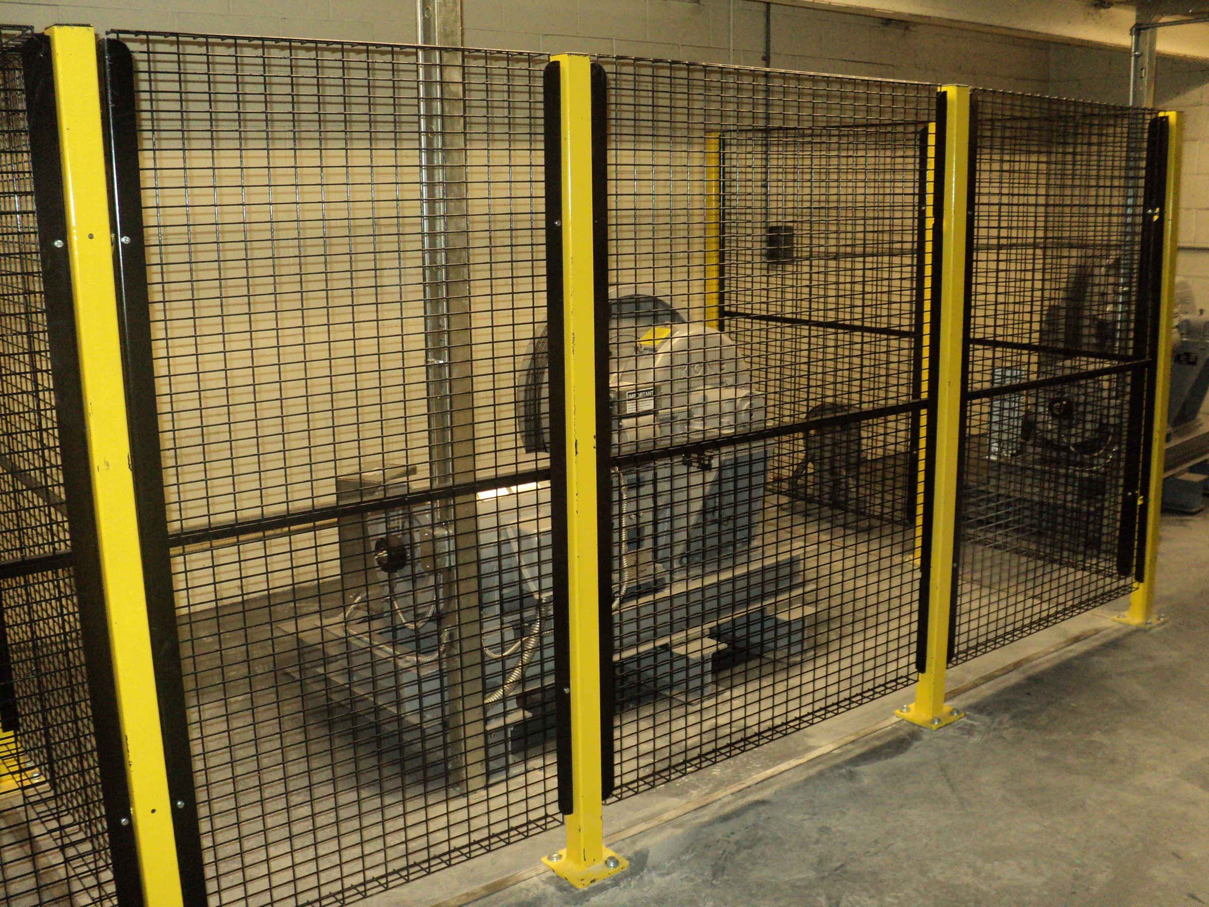 Wire mesh guarding panels around equipment in an elevator machine room