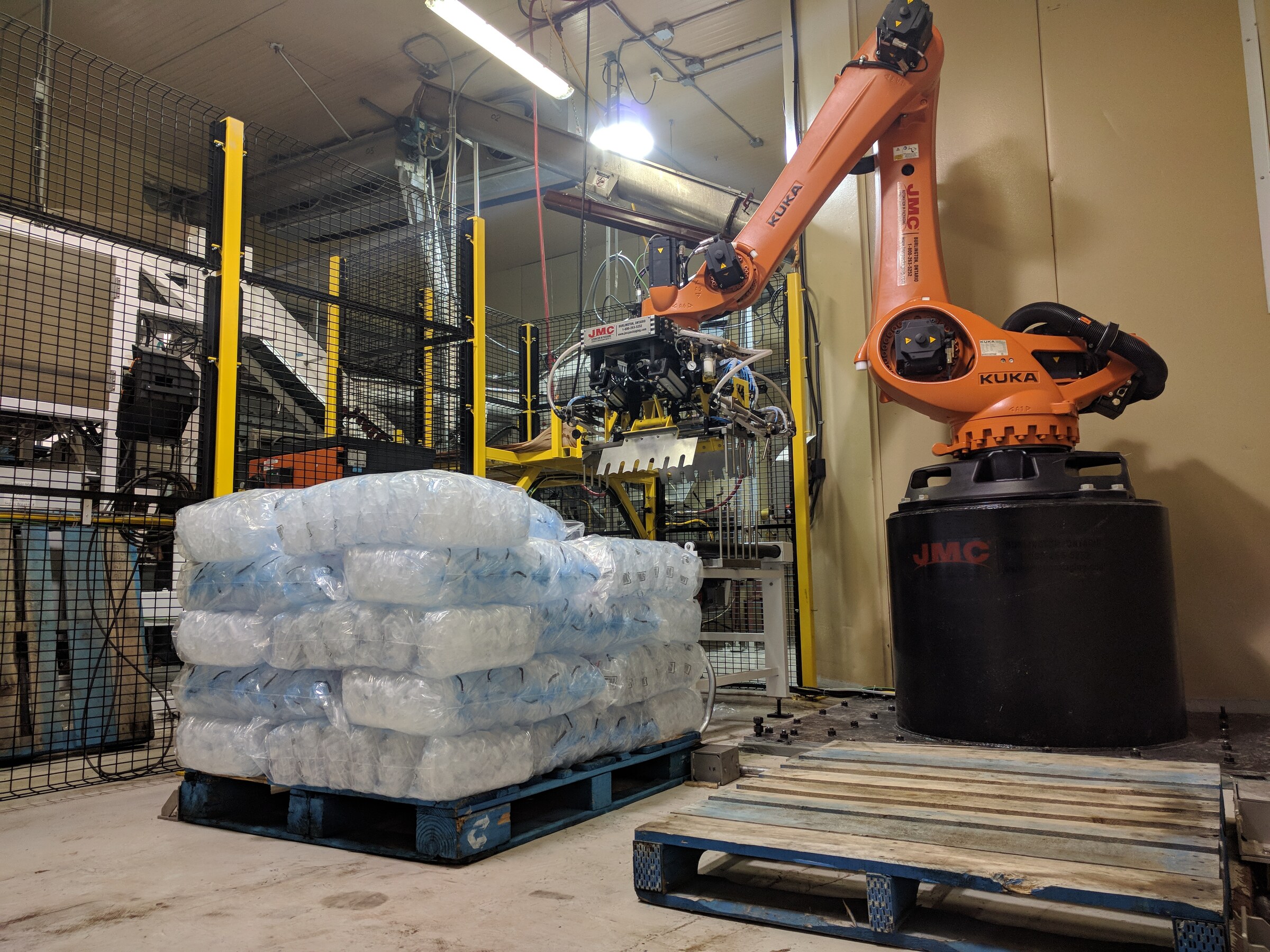Robotic palletizing cell on a packaging line with perimeter guarding
